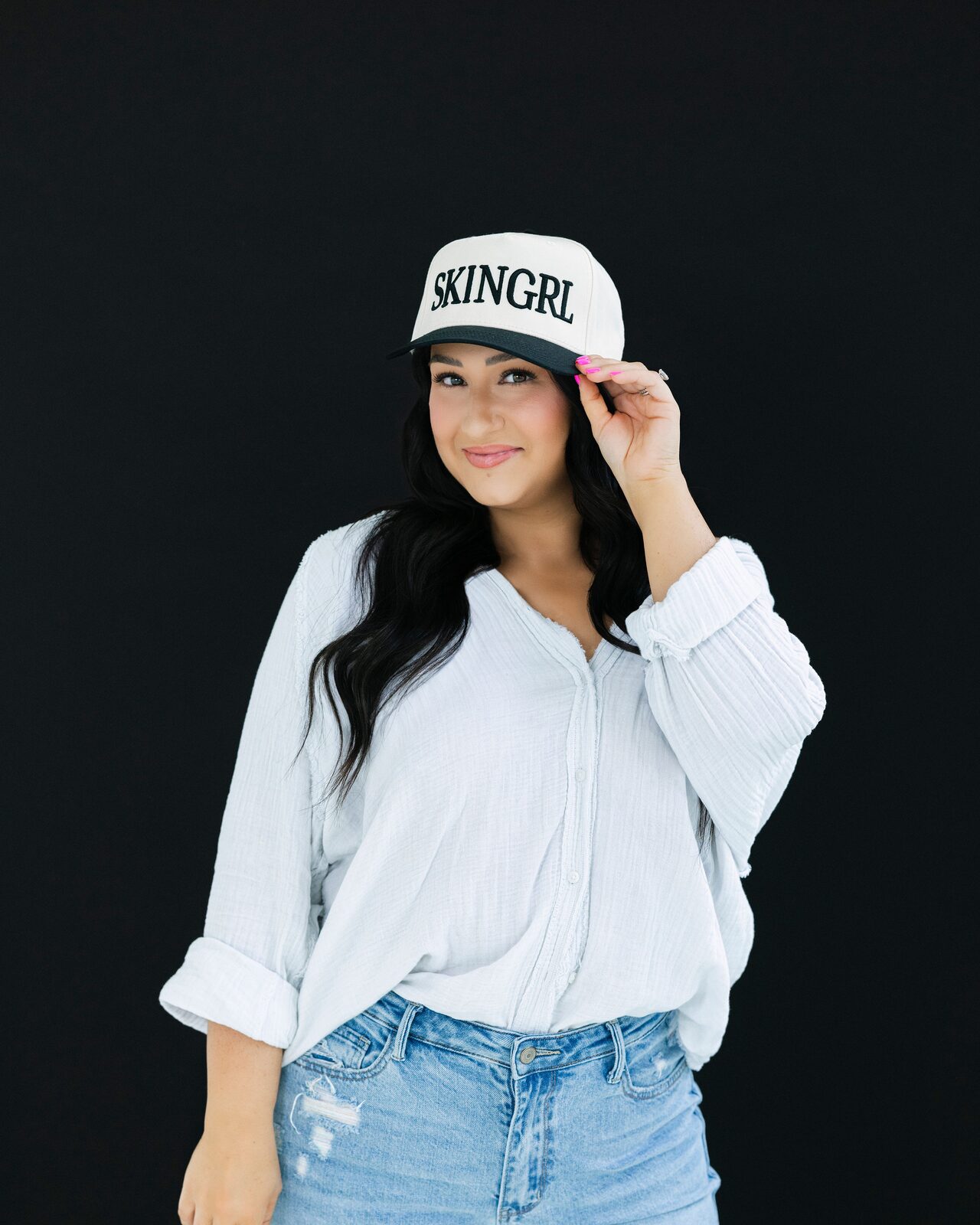 McKinzie tipping a white SKINGRL cap